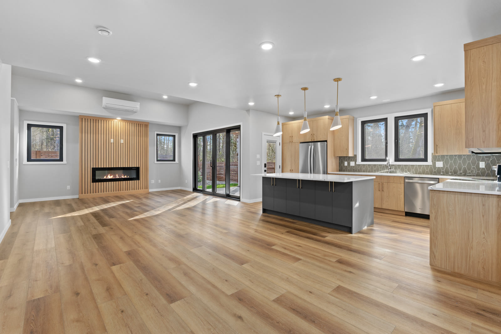 Open-concept light wood kitchen remodel with fireplace view