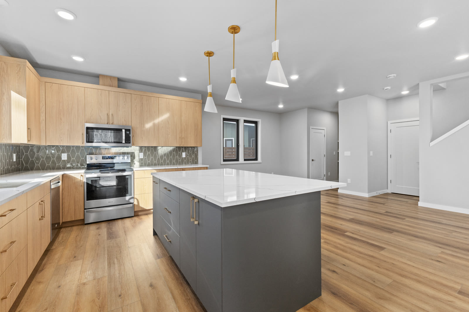 White Caniri kitchen cabinets with wall oven and quartz island
